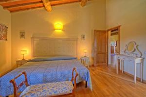 sypialnia z łóżkiem, stołem i lustrem w obiekcie Villa Il Caggio by PosarelliVillas w mieście San Gimignano +37 zdjęć