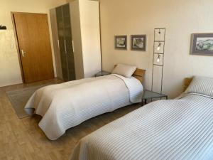 - une chambre avec 2 lits et une porte dans l'établissement Zweibettzimmer Business mit eigenem Bad ( Nichtraucher ), à Hanovre