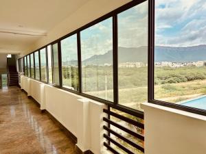 a room with large windows and a view of the mountains at Hotel Sitar Grand in Tirupati