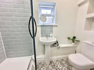 a white bathroom with a sink and a toilet at Blossoms Reach - 2 minutes from station and city centre in York