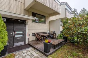 a patio with a wooden table and a wooden bench at Happy Home Lauttasaari in Helsinki