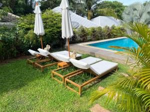 a group of chairs and umbrellas next to a pool at New Seahorse Residence in Amphoe Koksamui