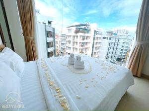 a hotel room with a bed with pearl jewelry on it at BELLA VT HOTEL in Vung Tau