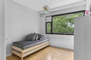uma cama num quarto com uma janela em Happy Home Lauttasaari em Helsinque