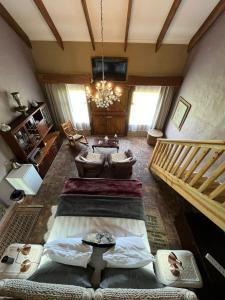 a living room with two beds and a chandelier at TNiqua Stable Inn in Plettenberg Bay