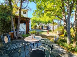 Un patio con una mesa y sillas en un patio. en La Bohéme Gastehuis, en Bloemfontein