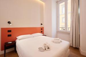 a bedroom with a white bed with towels on it at DEM Hotel in Rome