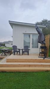 a patio with two chairs and an umbrella at Attefallshuset in Hyllinge