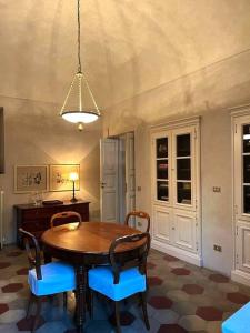 een eetkamer met een houten tafel en blauwe stoelen bij Suite Vittorio Emanuele in Alba