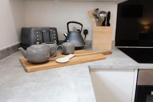 a kitchen counter with a cutting board and a tea kettle at BOURNECOAST - TOWN CENTRE - BEACH 10 min WALK - GARDEN PATIO - 8421 in Bournemouth +36 photos