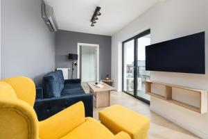 a living room with a couch and a tv at Air-Conditioned Seaside Apartment with Parking & Balcony by Renters in Ustronie Morskie