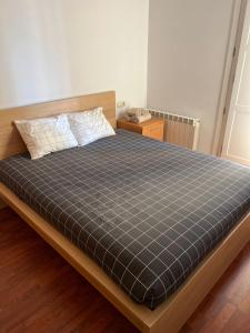 a bedroom with a bed with a blue checkered blanket at Comodidad en el Centro de Haro in Haro