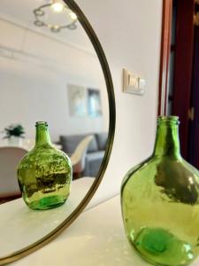 un vaso verde seduto su un tavolo di fronte a uno specchio di Comodidad en el Centro de Haro a Haro
