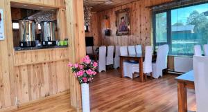 une salle à manger avec des chaises blanches, une table et des fleurs dans l'établissement Terelj Altai Resort, à Nalayh