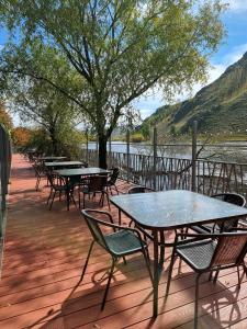 une rangée de tables et de chaises sur une terrasse avec un arbre dans l'établissement Terelj Altai Resort, à Nalayh