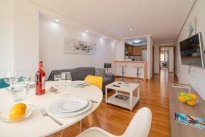 uma cozinha e sala de estar com uma mesa branca e cadeiras em Lanzahost LUX XXI em Arrecife