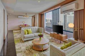 a living room with a couch and a tv at Eastwood Richmonde Hotel Quezon City in Manila