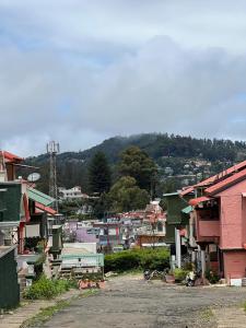 a view of a town with a mountain in the background at Sumana Stays in Ooty