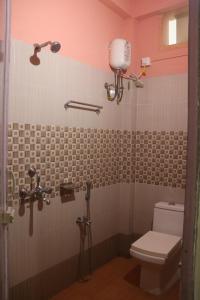a bathroom with a toilet and a shower at Kalapani Nest in Port Blair