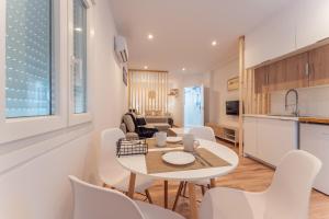 cocina y sala de estar con mesa y sillas en Apartamentos Turísticos Jardín del Albarregas en Merida