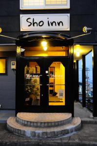 una tienda con un cartel en la puerta en Sho inn MINIMAL HOTEL 小樽駅から無料送迎あり, en Otaru