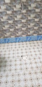 a bathroom with a tiled floor and a tile wall at SANYANG in Sanyang