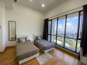 a bedroom with two beds and a large window at KL Gateway Penthouse w Karaoke by Cobnb in Kuala Lumpur