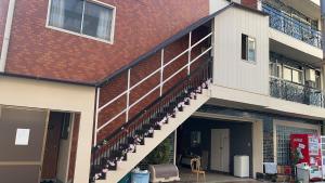 a building with a staircase on the side of it at Nippori Osaka Nishi-Tengachaya Guesthouse西天下茶屋アパートメント in Osaka