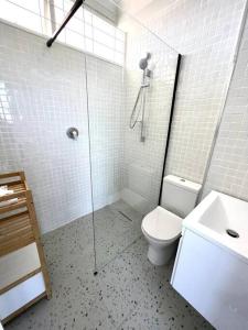 a bathroom with a shower and a toilet and a sink at Charming beachfront Strand apartment in Cape Town +18 photos