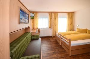 1 dormitorio con 1 cama y 1 sofá en Ferienhof Wölflbauer en Saalbach Hinterglemm