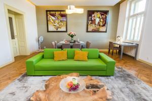 ein grünes Sofa im Wohnzimmer mit einem Tisch in der Unterkunft Bellevue Apartment in Prag