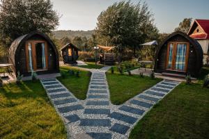 einen Garten mit einem Kopfsteinpflasterweg vor zwei Cottages in der Unterkunft Glamp In Style Pods Resort in Bran