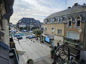 uma vista para uma rua da cidade com carros e edifícios em Place Morny, maison de ville, 2 chambres, terrasse em Deauville