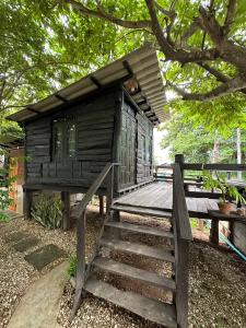 eine kleine Holzhütte mit einer Holztreppe, die dorthin führt. in der Unterkunft The Legend Homestay. in Mae Ai Chiang Mai
