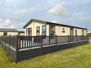 una casa con una valla negra delante de ella en Modern Lodge with Amazing Views en Newquay