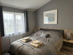 a bedroom with a bed with two towels on it at Modern Lodge with Amazing Views in Newquay +36 photos