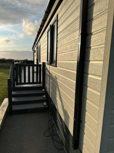 un porche de una casa con escaleras en Modern Lodge with Amazing Views en Newquay