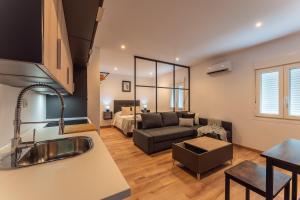 cocina y sala de estar con sofá y mesa en Apartamentos Turísticos Jardín del Albarregas en Merida