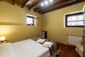 a bedroom with a bed with two towels on it at Casa La Aldea de Guadamia in Llames de Pría