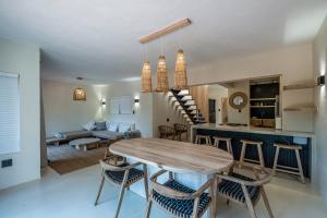 a kitchen and living room with a wooden table and chairs at SALT in Jeffreys Bay +20 photos