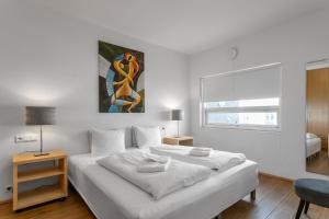レイキャビクにあるBaldursbrá Apartment Laugavegurの白いベッドルーム(大型ベッド1台、窓付)
