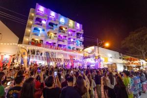 une foule de personnes debout devant un bâtiment la nuit dans l'établissement Yuu Hotel Ubon Ratchathani, à Ubon Ratchathani