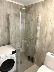 W łazience znajduje się prysznic i pralka. w obiekcie Tromsdalen Aurora Apartments w mieście Tromsø