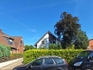 due auto parcheggiate di fronte a una casa di Ferienwohnung Abendsonne, Winsen a Winsen