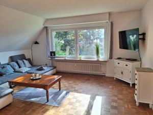 un soggiorno con divano, tavolo e finestra di Ferienwohnung Abendsonne, Winsen a Winsen