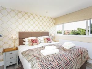 1 dormitorio con 1 cama con toallas en The Orange Tree Thornham en Thornham