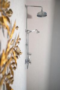 a shower in a bathroom with a light on the wall at Chateau Pont Saint-Martin in Léognan