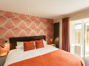a bedroom with a bed with an orange blanket at The Orange Tree Thornham in Thornham