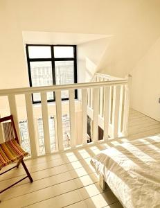 1 dormitorio con 1 cama y escalera con ventana en Le Crotoy - Entre ciel et mer, en Le Crotoy