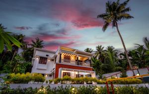 ein Haus am Strand mit einer Palme in der Unterkunft The Vogue - Luxury Private Pool Villa , Athirappilly in Athirappilly